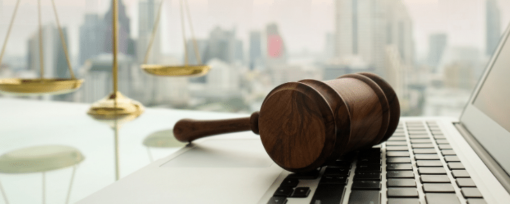 judge's gavel sitting on laptop keyboard
