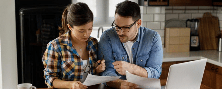 white man and woman couple looking at bills