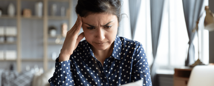 asian woman reading letter looking frustrated
