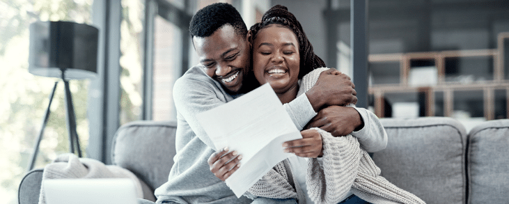 black man and woman hugging on couch