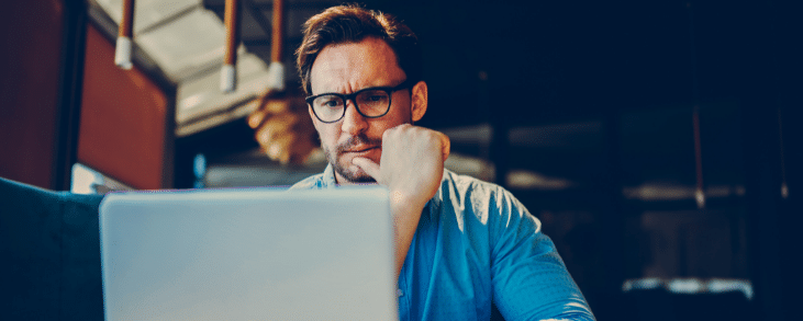 white man looking at laptop thinking about ucc filing