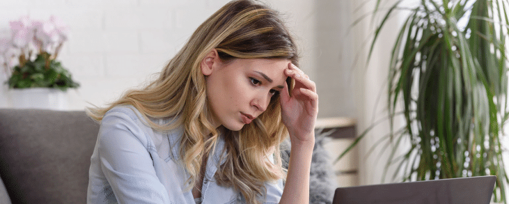 white woman with hand on forehead looking worried